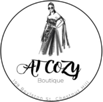 A circular black and white logo for 'At Cozy Boutique' featuring an illustration of a woman in a long dress, with the boutique name and address printed below.